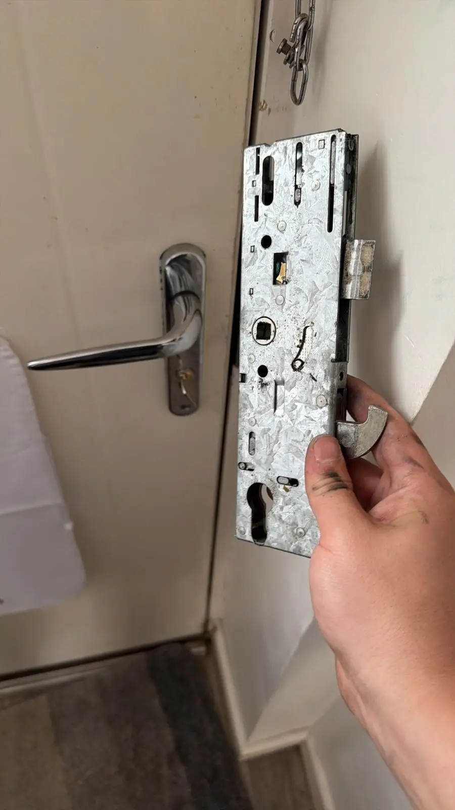 A multipoint lock mechanism held against the edge of a white door
