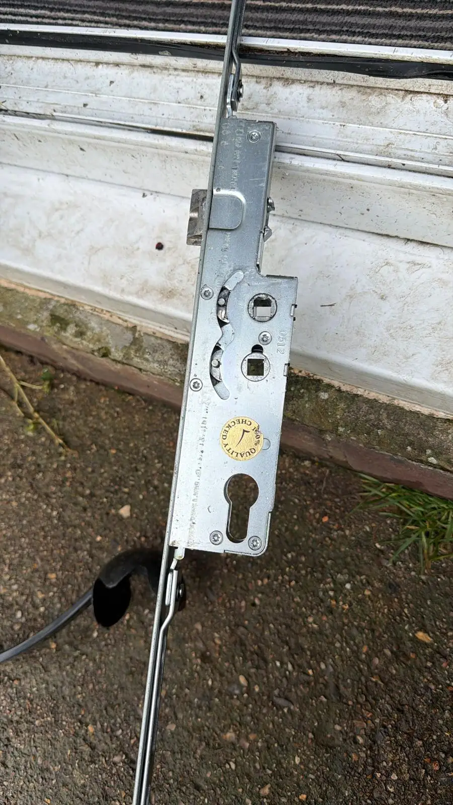 A multipoint lock strip laid on the ground outside a door