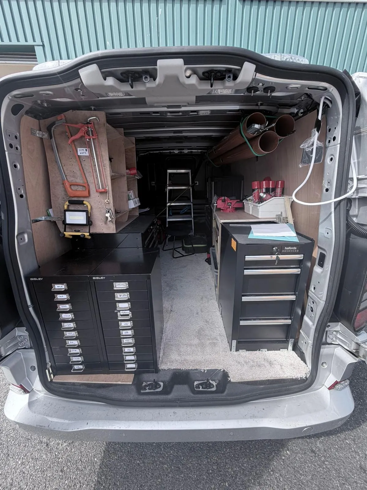 The back of Morgan’s van, fitted out with drawers, tool cases and a workbench